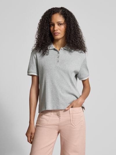 Modelka kobieca ma na sobie Regular Fit Poloshirt aus Baumwolle od Jake*s Casual, jasnoszara bawełna, krój regular fit, polokołnierzyk, elastyczne wykończenia rękawów, długość pleców w rozmiarze M: 54 cm, widok całej sylwetki z przodu.