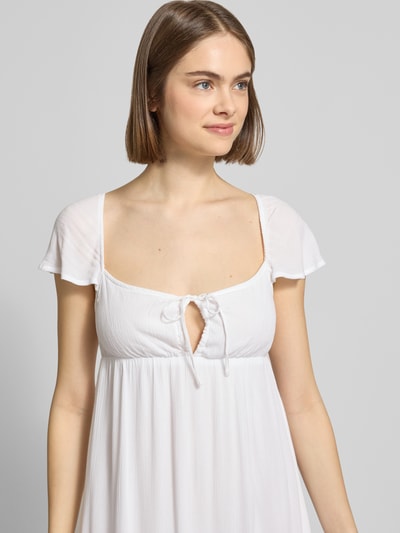Frauenmodel trägt Babydoll Kleid aus Viskose mit Karree-Ausschnitt und Schleife von REVIEW, Reine Viskose, Gerader-Schnitt, Minikleid, Nahaufnahme Oberkörper.