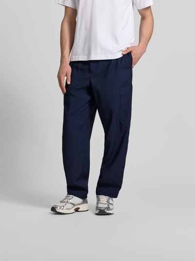 Männermodel trägt Straight Fit Sweatpants aus Viskose-Mix von Kenzo in Dunkelblau mit Cargo-Tasche, elastischem Bund und Tunnelzug, Ganzkörperansicht von vorne.