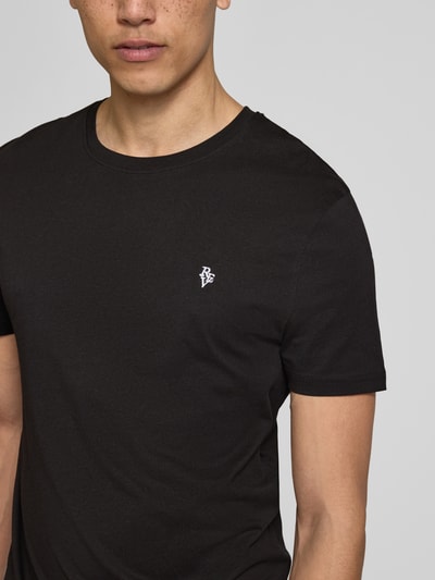 Männermodel trägt Basic Slim Fit T-Shirt mit Flock-Logo auf der Brust von REVIEW, Schwarz, Baumwoll-Viskose-Mix, Nahaufnahme Oberkörper.