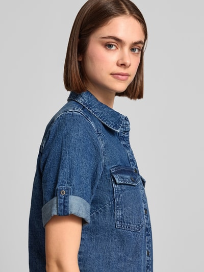 Frauenmodel trägt Jeanskleid mit Brusttaschen Modell 'NEW SIGNE' von Noisy May aus Reine Baumwolle, Hemdblusenkragen, Ärmel mit Aufschlag, Gerader-Schnitt, Minikleid, Nahaufnahme Oberkörper.