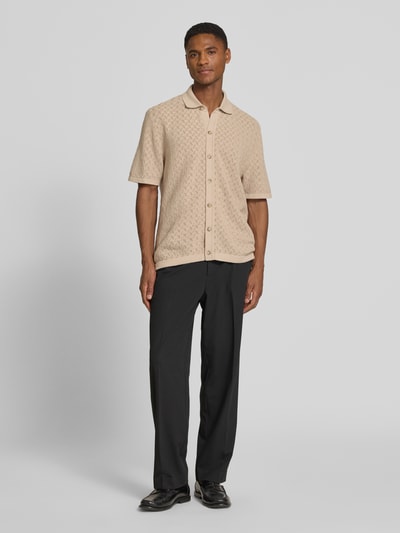 Männermodel trägt Relaxed Fit Freizeithemd aus reiner Baumwolle Modell 'NAPPO' von BOSS in Strickoptik, sandfarben, Ganzkörperansicht von vorne.