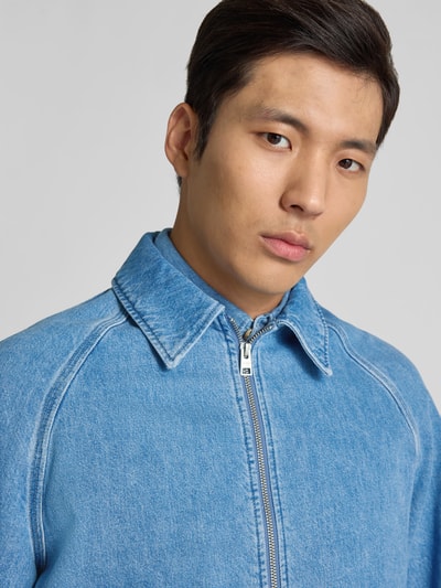 Männermodel trägt Regular Fit Jeansjacke mit Umlegekragen von Closed aus reiner Baumwolle, hellblau, Zweiwege-Reißverschluss, Nahaufnahme Oberkörper.