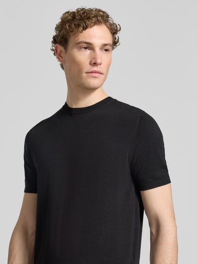 Männermodel trägt Strickshirt mit Rundhalsausschnitt von MARKUP, Regular Fit in Schwarz, feine Struktur, Nahaufnahme Oberkörper.