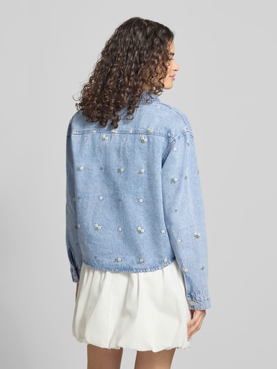 Vrouwenmodel draagt regular fit jeansjack uit puur katoen model 'CASSIE' van ONLY, lichtblauw met bloemen, dames, totaalbeeld achteraan.