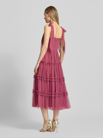 Frauenmodel trägt Knielanges Cocktailkleid mit Smok-Details von LACE & BEADS, Mesh, A-Linie, Stufen-Look, Schnürung, Knielänge, Ganzkörperansicht Rückansicht.