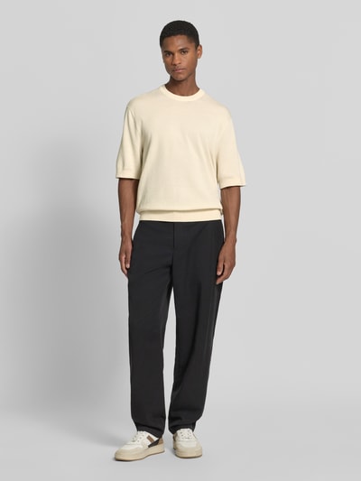 Mężczyznę model prezentuje Relaxed Fit T-Shirt aus reiner Baumwolle Modell 'TORINO' von SELECTED HOME, kolor kremowy, okrągły dekolt, krótkie rękawy, struktura dzianiny, pełny widok z przodu.