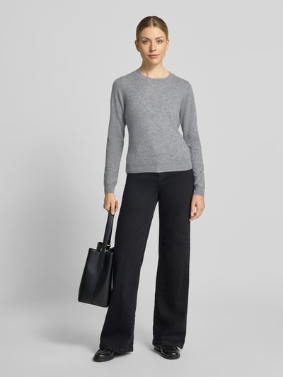 Modelka nosi Slim Fit Strickpullover aus reinem Kaschmir od Christian Berg Woman, krój slim fit, kaszmir, taliowany, elastyczne wykończenia, długość tyłu w rozmiarze S: 54 cm, długość rękawów w rozmiarze S: 65 cm, widok całej sylwetki z przodu.