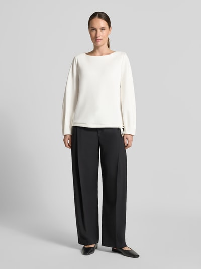 Modelka prezentuje kremową bluzę Relaxed Fit Sweatshirt aus Viskose-Mix von s.Oliver BLACK LABEL i czarne spodnie, całkowity widok z przodu.