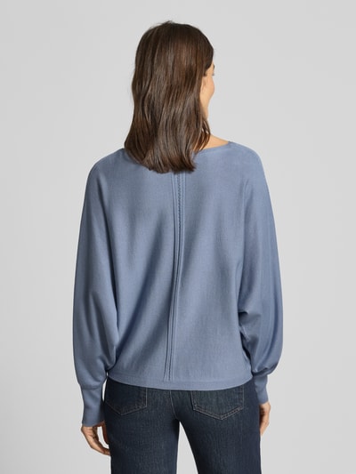 Frauenmodel trägt Oversized Strickpullover aus Viskose-Mix von s.Oliver BLACK LABEL in Optik: Unifarben, Passform: Oversized, Materialverarbeitung: Strick, Label-Applikation, Langarm, U-Boot-Ausschnitt, Ärmelabschluss gerippt, Ganzkörperansicht Rückansicht.