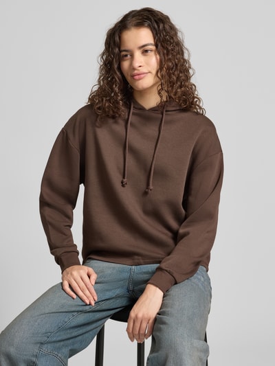 Frauenmodel trägt Regular Fit Hoodie aus Baumwoll-Mix Modell 'CHILLI' von PIECES in Braun, strukturierte Oberfläche, Ganzkörperansicht von vorne.