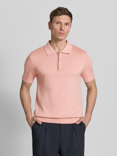Männermodel trägt Regular Fit Poloshirt aus reiner Wolle Modell 'TRAY' von SELECTED HOMME in Uni-Rosa, Strick, Nahaufnahme Oberkörper.