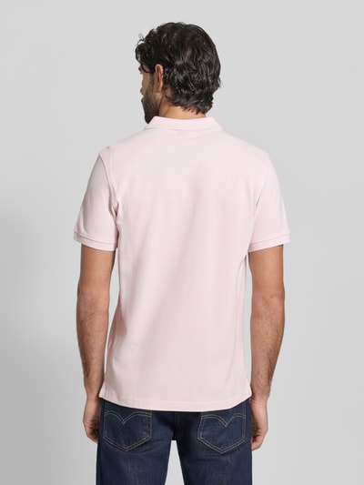 Männermodel trägt Slim Fit Poloshirt mit Logo-Stitching von MCNEAL in zartem Rosa, reine Baumwolle, Polokragen, Ganzkörperansicht Rückansicht.