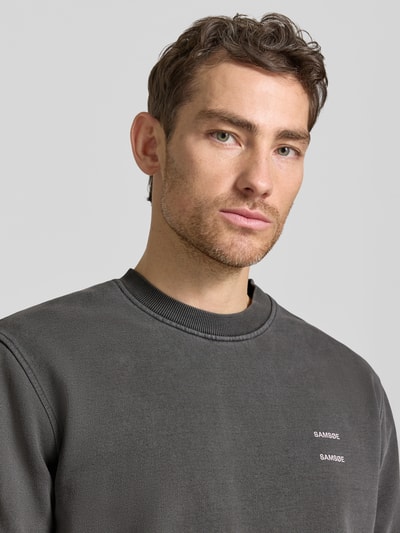 Männermodel trägt Sweatshirt mit Logo-Print Modell 'JOEL' von Samsøe Samsøe, Baumwoll-Mix, Relaxed Fit, Nahaufnahme Oberkörper