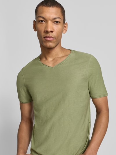 Männermodel trägt T-Shirt mit geripptem Rundhalsausschnitt von MCNEAL in Olivgrün, Regular-Fit, Rückenlänge 65 cm bei Größe M, Nahaufnahme Oberkörper.