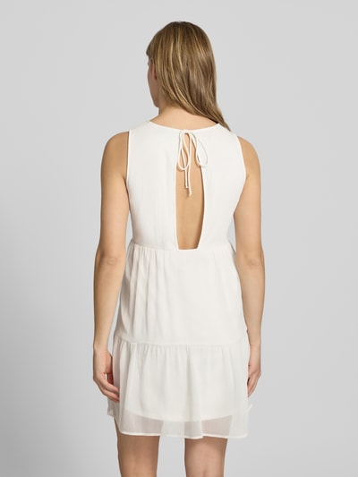 Frauenmodel trägt Regular Fit Chiffonkleid in Crêpe-Optik Modell 'LARA' von Pieces, unifarben, Mini-Länge, Rückenausschnitt mit Bindeband, Ganzkörperansicht Rückansicht.