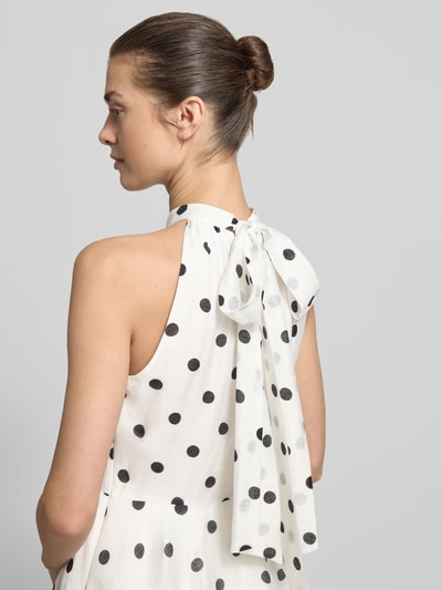 Vrouwenmodel draagt Midikleid im Stufen-Look Modell 'Monroe' van Forever New, wit met zwarte stippen, lyocell-mix met linnen, getailleerde fit, rugstrik, detailopname rugaanzicht.