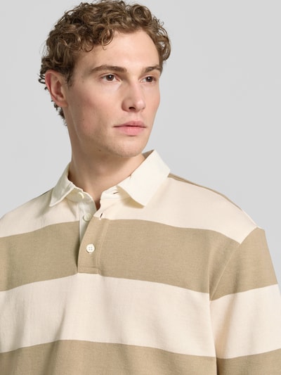 Männermodel trägt Relaxed Fit Poloshirt im Allover-Look von MCNEAL aus Baumwoll-Mix mit Knopfleiste, beige-weiß gestreift, Nahaufnahme Oberkörper. Rückenlänge bei Größe M 70 cm.