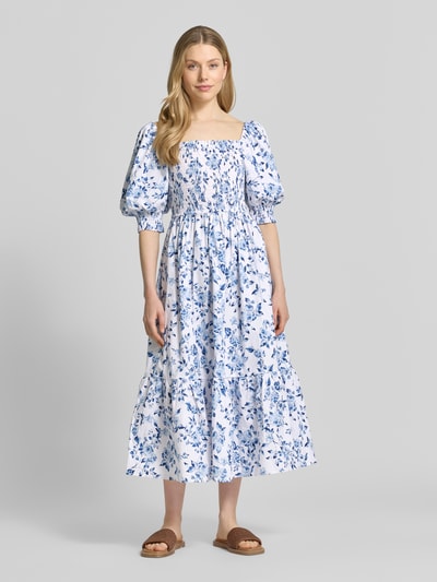 Frauenmodel trägt Midikleid mit Karree-Ausschnitt und Puffärmeln von Apricot, weiß-blaues Allover-Blumenmuster, A-Linie, Ganzkörperansicht von vorne. Baumwoll-Elasthan-Mix, Rückenlänge 110 cm, Brustweite 31 cm, Ärmellänge 37 cm.