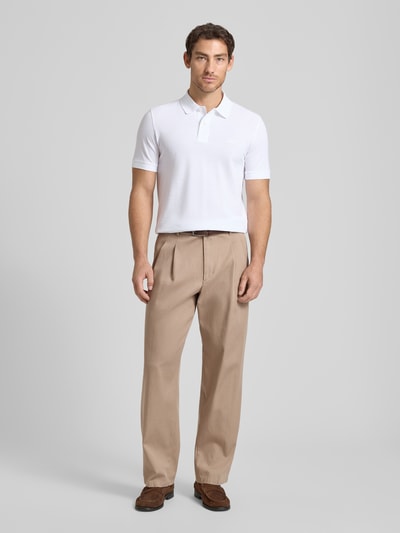Męski model nosi Regular Fit Poloshirt aus reiner Baumwolle Modell 'PALLAS' od BOSS, gładka biała bawełna pikowana, krój regular fit, krótki rękaw, kołnierzyk polo, logo, widok całej sylwetki z przodu.
