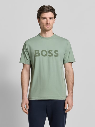 Männermodel trägt Regular Fit T-Shirt aus Baumwoll-Mix Modell 'ICONIC' von BOSS Green, unifarben, Label-Prägung, Ganzkörperansicht von vorne.