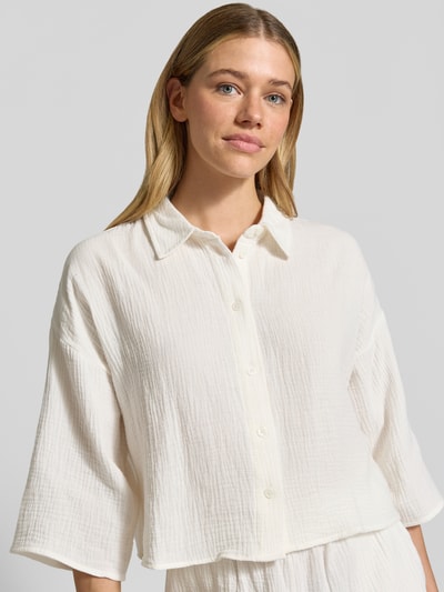 Frauenmodel trägt Loose Fit Hemdbluse aus reiner Baumwolle Modell 'NATALI' von Vero Moda, Optik: Unifarben, 3/4-Arm, Seersucker, Nahaufnahme Oberkörper.
