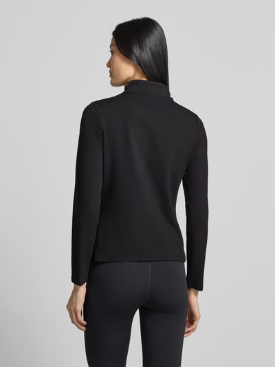 Frauenmodel trägt schwarze Slim Fit Trainingsjacke mit Logo-Print von Under Armour, glatte Textur, Damen Trainingsjacke, Ganzkörperansicht Rückansicht.