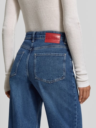 Frauenmodel trägt Straight Fit Jeans aus Baumwoll-Mix von MYON, klassisches 5-Pocket-Design in Mittelblau, Nahaufnahme Rückansicht, elastischer Stoff, Knopf- und Reißverschluss, Bundweite 38 cm, Innenbeinlänge 79 cm.