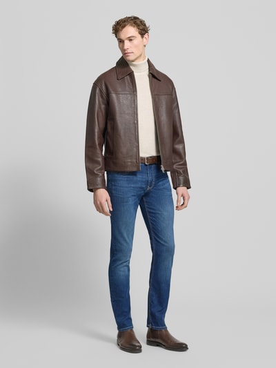 Männermodel trägt Jeans mit Eingrifftaschen Modell 'ARNE PIPE' von MAC in Blau, Slim Fit, Baumwoll-Mix mit Stretch-Anteil, Ganzkörperansicht von vorne.