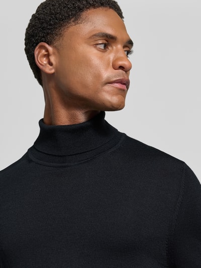 Männermodel trägt Wollpullover mit Rollkragen von Christian Berg Men, Woll-Mix, schwarze Farbe, gerippte Abschlüsse, Nahaufnahme Oberkörper.