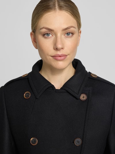 Frauenmodel trägt Mantel aus Schurwoll-Mix mit Kunstfell Modell 'BRADWALL' von DRYKORN in Schwarz mit Knopfverschluss, Nahaufnahme Oberkörper. Schurwoll-Mix, Slim Fit, Zweireiher, Eingrifftaschen.