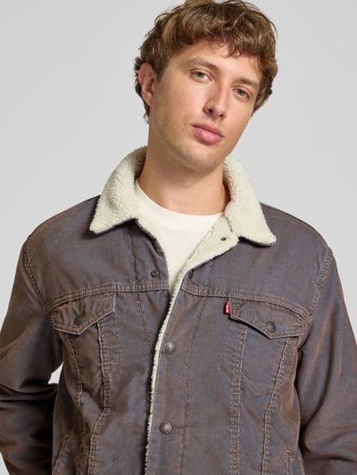 Männermodel trägt Relaxed Fit Jeansjacke aus Baumwoll-Mix von Levi's®, braune Töne, sichtbare Nähte, Nahaufnahme Oberkörper.