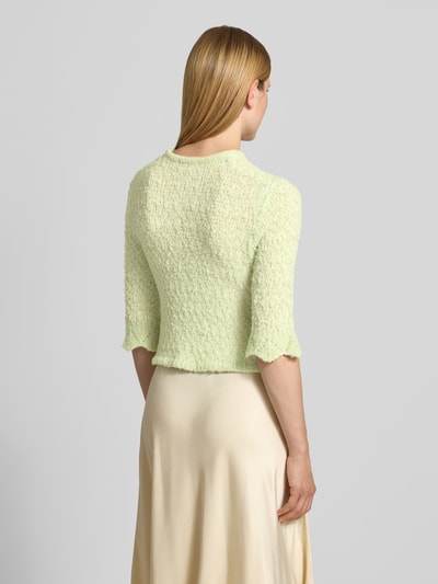 Frauenmodel trägt Strickjacke aus Lanawolle-Mix mit 3/4-Arm von Christian Berg Woman in Hellgrün, feine Struktur, Ganzkörperansicht Rückansicht, Slim-Fit, Rundhalsausschnitt, Knopfleiste, Stretch-Anteil, Rückenlänge bei Größe S 47 cm, Ärmellänge 42 cm.