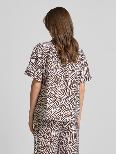 Frauenmodel trägt Regular Fit Bluse mit V-Ausschnitt Modell 'Mele' von FREE/QUENT im braun-weißen Allover-Look, Rückansicht.
