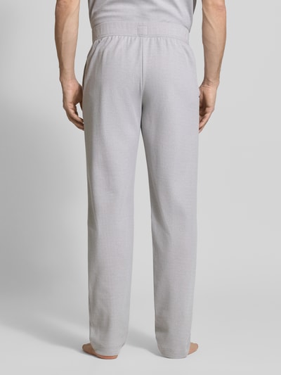 Männermodel trägt Sweatpants mit elastischem Bund von Schiesser aus Baumwoll-Mix, Relaxed-Fit, fein strukturiert, Ganzkörperansicht Rückansicht.
