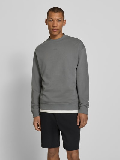 Männermodel trägt Regular Fit Sweatshirt aus reiner Baumwolle Modell 'DAPOCREW' von HUGO in Grau, Unifarben, Ganzkörperansicht von vorne