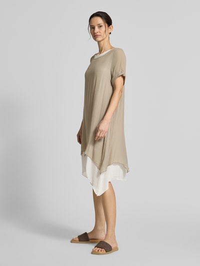 Modelka nosi Knielanges Kleid aus Viskose-Mix von Apricot, beżowo-białe kolory, prosty krój, dekolt okrągły, rękawy z mankietami, długość do kolan, długość z tyłu w rozmiarze S: 94 cm, szerokość w rozmiarze S: 49 cm, długość rękawa w rozmiarze S: 22 cm, widok całej sylwetki z przodu