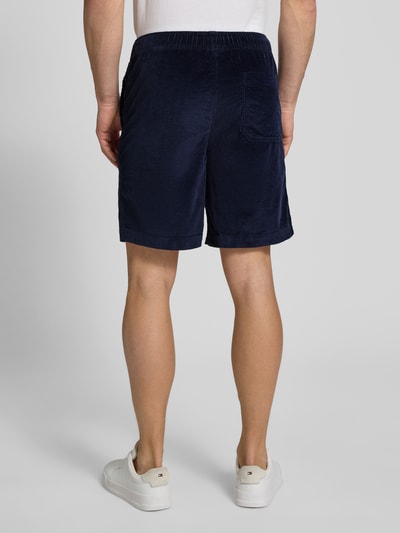Mężczyzna nosi Regular Fit Sweatshorts aus Baumwoll-Mix von SELECTED HOMME, efekt: jednolity kolor, krój regular fit, tunel, ściągacz, kieszeń z tyłu, wpuszczane kieszenie, wykończenie materiału: sztruks, mieszanka bawełny, widok całej sylwetki z tyłu.