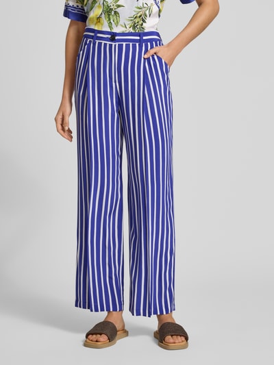 Frauenmodel trägt Hose aus Viskose im Allover-Look von Marc Cain, blau-weiß, weites Bein, Eingrifftaschen, Nahaufnahme Oberkörper.