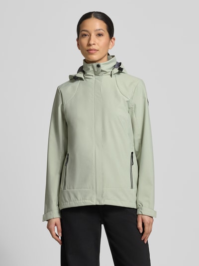 Frauenmodel trägt Parka mit Kapuze und verdecktem Reißverschluss von G.I.G.A. DX, hellgrün, glatte Textur, seitliche Zipper, Ganzkörperansicht von vorne