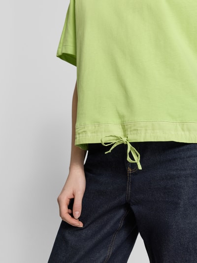 Frauenmodel trägt Oversized T-Shirt mit Rundhalsausschnitt von Smith and Soul in Hellgrün, Reine Baumwolle, Saum mit Kordelzug, Nahaufnahme Oberkörper.