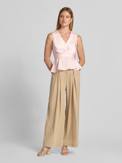 Frauenmodel trägt Blusentop in Wickel-Optik Modell 'Risetta' von Neo Noir in Rosa, V-Ausschnitt, Slim Fit, Material-Mix mit Stretch, Ganzkörperansicht von vorne.