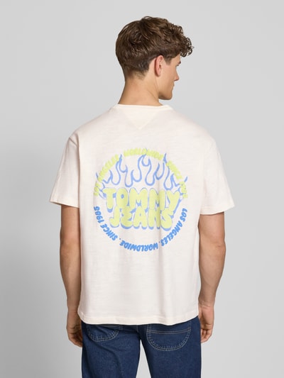 Männermodel trägt Relaxed Fit T-Shirt aus reiner Baumwolle von Tommy Jeans, Optik: Unifarben, Label-Print, Ganzkörperansicht Rückansicht.