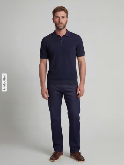 Männermodel trägt Slim Fit Poloshirt mit Strukturmuster von Christian Berg Men, reine Baumwolle, dunkelblau, Ganzkörperansicht von vorne.
