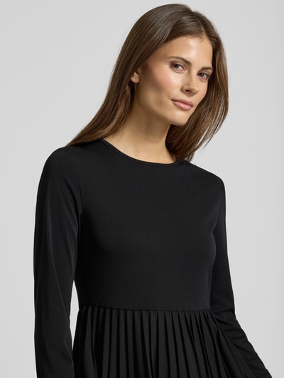 Vrouwenmodel draagt Maxi-Freizeitkleid im Set mit Strick-Pullunder aus reiner Schurwolle Modell 'EBRO' van Weekend Max Mara, effen zwart, lange mouwen, ronde hals, plissé-chiffon textuur, losse pasvorm. Nahaufnahme bovenlichaam.