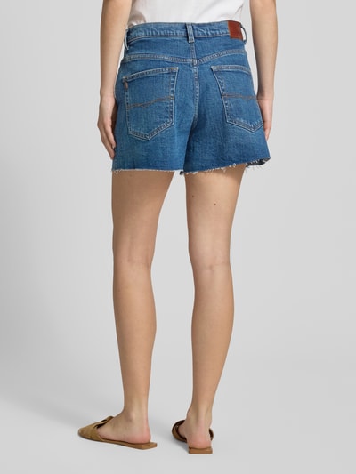 Vrouwenmodel draagt Damen Jeansshorts met katoenmix van Pepe Jeans in middelblauw, ruwe zoom, rechte pasvorm, detailopname, rugaanzicht.
