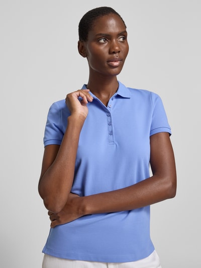 Frauenmodel trägt Slim Fit Poloshirt mit Knopfleiste von Christian Berg Woman aus Baumwoll-Elasthan-Mix, Seitenschlitze, Rückenlänge 62 cm, Nahaufnahme Oberkörper.