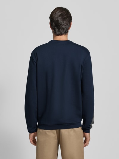 Männermodel trägt Sweatshirt mit Logo und Rundhalsausschnitt von EA7 Emporio Armani in Dunkelblau, reine Baumwolle, Regular Fit, Ganzkörperansicht Rückansicht.