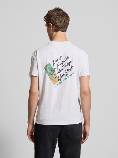 Männermodel trägt Regular Fit T-Shirt aus reiner Baumwolle von Tommy Jeans, unifarben mit Label Print, Jersey-Textur, Ganzkörperansicht Rückansicht.