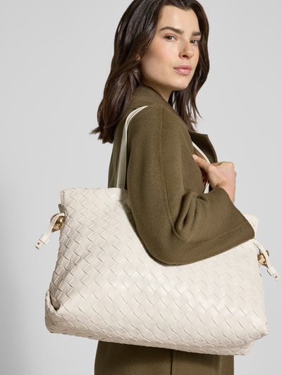 Frauenmodel trägt Tote Bag in Leder-Optik Modell 'Riccy' von Liu Jo White in Flecht-Optik, cremefarben, Nahaufnahme Oberkörper. Hauptfach mit Magnetverschluss, schmales Schulterriemen, Innenfach mit Reißverschluss, Maße ca. 40x30x17 cm, Riemenlänge 57 cm.